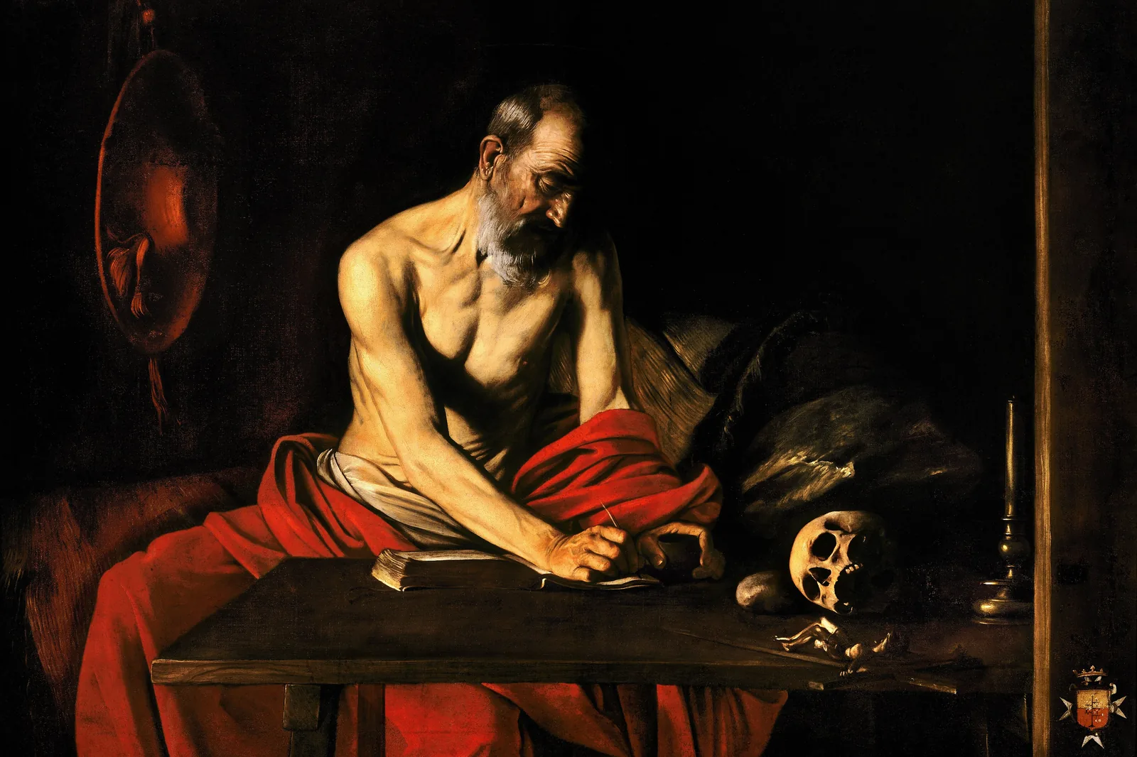 San Girolamo che scrive del Caravaggio: un anziano avvolto in un panno rosso chino su una scrivania, un teschio accanto alle sue carte, in una stanza buia